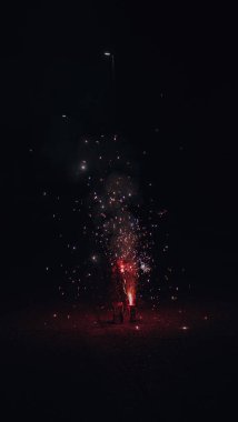 Turuncu, siyah gökyüzü arka planında bulanık havai fişek ışıkları. Yeni yıl ve Noel kavramı.