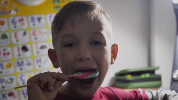 El chiquitín come los bombones enormes con las piruletas, el primer plano - el azúcar alto — Vídeo de stock