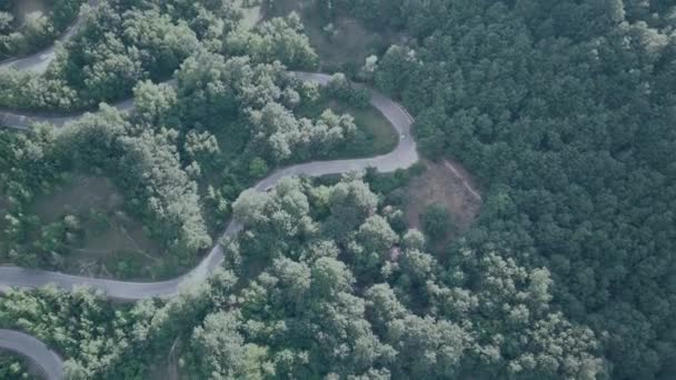 Filmación B rollo de vista aérea avión no tripulado volando sobre el paisaje serpentina sinuosa carretera. Drone 4K Video. camino serpenteando en las montañas en verano día soleado — Vídeo de stock