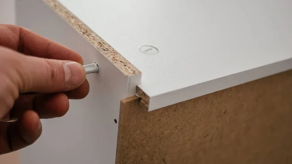 The process of assembling furniture from chipboard with a cordless screwdriver, close-up — Stock Photo, Image