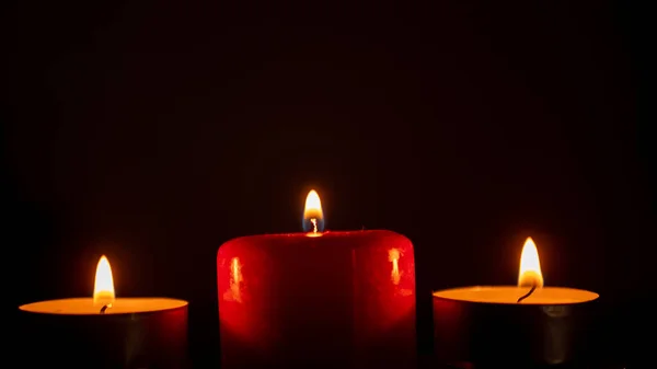 Três velas em um fundo preto. de perto — Fotografia de Stock