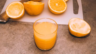 Sıkıştırılmış portakal suyu ve taze portakal meyveleri ahşap masada..