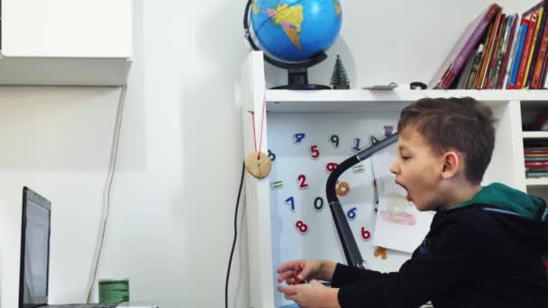 The boy became bored, yawning at a desk in an online school — Video Stock