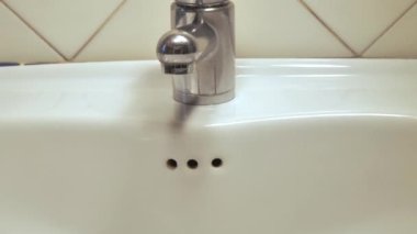 Musluk açılır, su kanalizasyona akar, sonra da kapatılır. Su dök, musluğu kır.