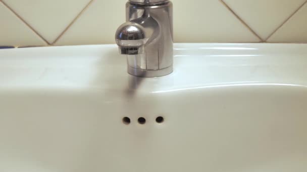 De kraan wordt geopend, het water stroomt in het afvoerbassin, daarna werd gesloten. Giet water, barst in de kraan — Stockvideo