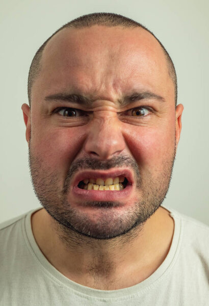 Closeup portrait of funny angry young bully man sticking his tongue out at you camera gesture, isolated on white background. You are disgusting concept