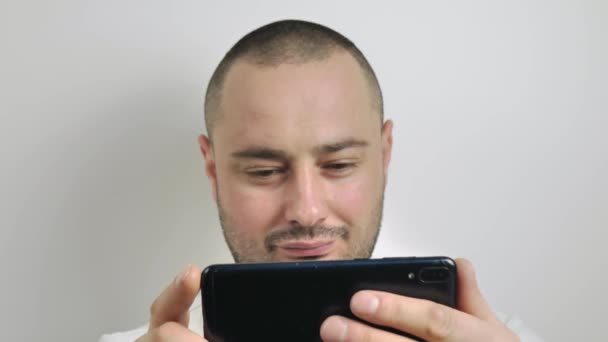 Man watching video on the phone. close up on a white background — Stock Video