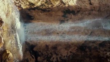 Güneş parlarken küçük kayalıklarda şelale. Şelale her şeyi ferahlatıyor. Suyun sesi çok rahatlatıcı olabiliyor.