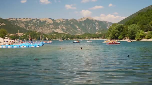 Napos nyár a Scano-tónál, Olaszországban. Az emberek fürdenek, és élvezik a pihenést a tiszta természetes víz a strandon Európában. — Stock videók