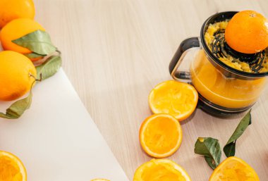 Sıkıştırılmış portakal suyu ve taze portakal meyveleri ahşap masada..