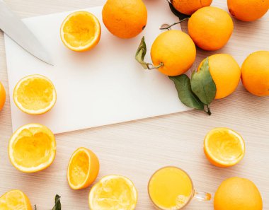 Sıkıştırılmış portakal suyu ve taze portakal meyveleri ahşap masada..