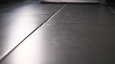 Döşemeleri süpürüp, yerleri süpürüp, evi temizleyip, kanepenin altını süpürüp, zemini yavaş çekimde süpürüyor.