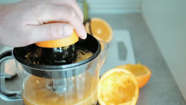 Man hand visa medan pressa färsk apelsin frukt på juicer, hälsosam frukost beredning, vitamin juice — Stockvideo
