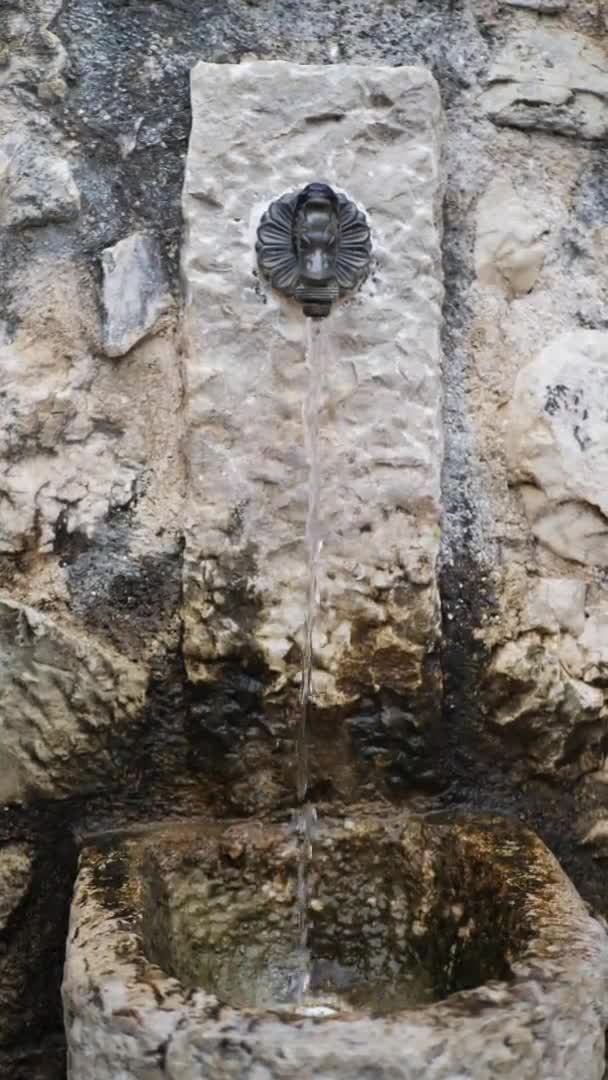 Вертикальное видео. Свежая холодная питьевая вода из чистого питьевого фонтана в Риме, Италия. Aqua работает без остановок — стоковое видео