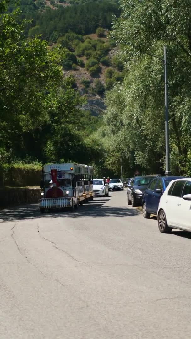 Italie Abruzzes, 22 août. 2020. vidéo verticale. Une locomotive touristique piétonne parcourt la promenade, le lac Scanno — Video