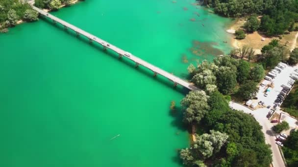 Egy drón kilőtt egy hidat. A tó mellett pihenő emberek — Stock videók