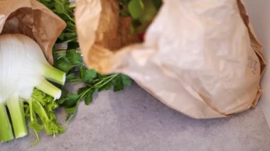 Adam kese kağıdından taze sebze seçiyor.