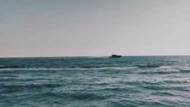 Sıcak bir yaz gününde açık bir gökyüzü ile Ostia yakınlarındaki denizi aşan bir tekne.