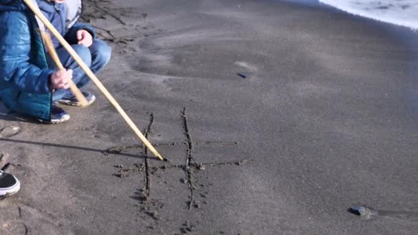 Mother and son on the sea sand play cross zero — Stock Video