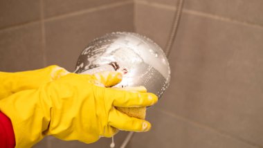 Kadın duş tepsisini yıkıyor.,