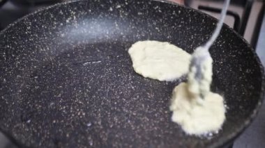 Aşçı tavada ekmek kırıntıları kızartıyor.