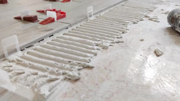 Installazione di piastrelle per pavimenti in ceramica - collocare la piastrella nella biancheria da letto materiale adesivo — Video Stock