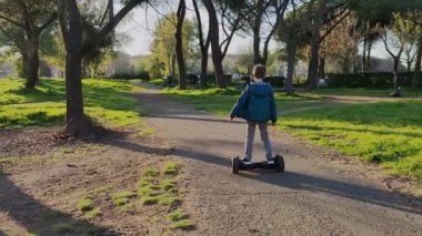Çocuk iki tekerlekli scooter kullanıyor.