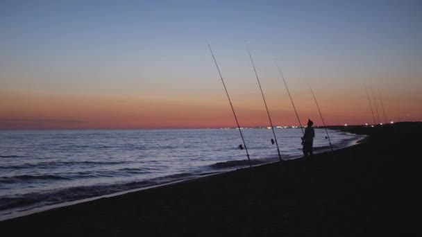 日没時に魚を待っている海の漁師。サーフフィッシングシーン. — ストック動画