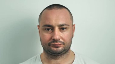 Adam yüzüne tıbbi maske takıyor. Beyaz arkaplanda kapat
