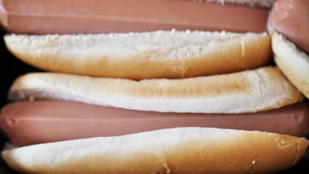 Salsichas em pães fatiados. espaços em branco para cachorro-quente. de perto — Vídeo de Stock
