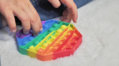 Elinde pembe bir Pop It Fidget oyuncağı var. Kapat.