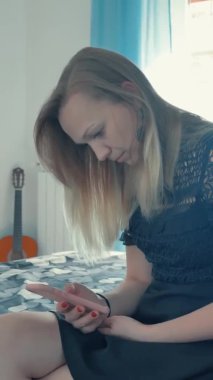 dikey video. Kız telefona bakar.
