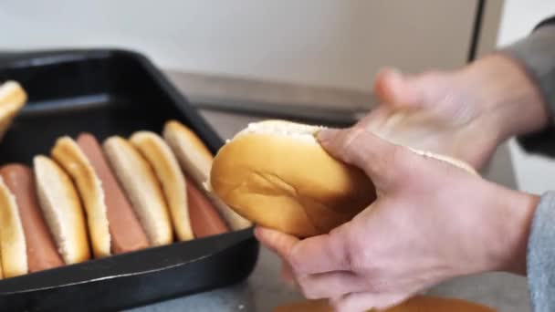 Nő vágja tekercs egy hot dog és tesz egy tál — Stock videók