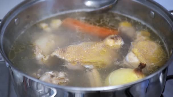 Tavuk çorbası gaz sobasında pişirilir, aşçı yağ toplar. — Stok video