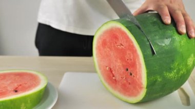 Adam tatlı yemek için karpuz dilimliyor..