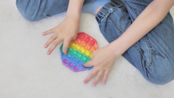 An unrecognizable baby is playing on the lawn grass. Selective focus on anti-stress toy — Stock Video