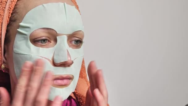 Woman applies a mask on her face — Stock Video