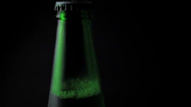 Siyah arka planda dönen bira şişesi