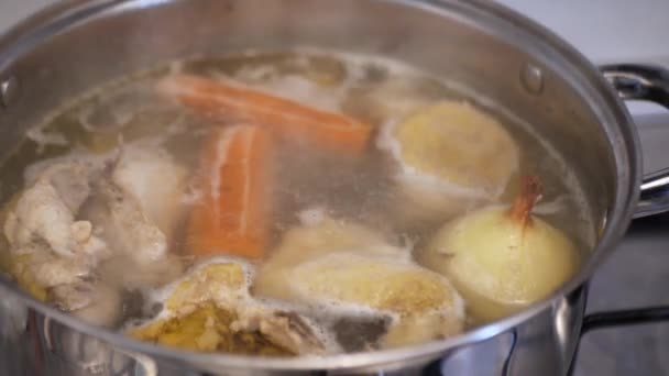 Caldo de galinha é cozido em um fogão a gás, o cozinheiro coleta gordura — Vídeo de Stock