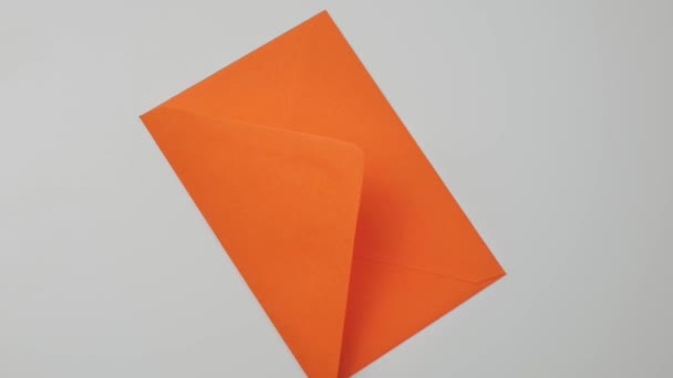 Orange post kuvert roterar på en vit platta, ovanifrån — Stockvideo