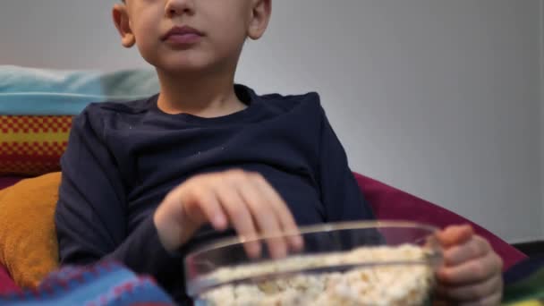 Chico viendo películas y comiendo palomitas de maíz, de cerca — Vídeos de Stock