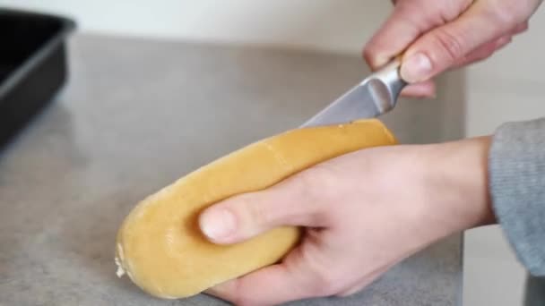 Bir kadın sosisli sandviç için ekmek keser ve bir kase koyar. — Stok video