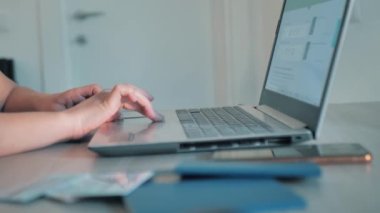 Kadın uçak biletlerini laptopla seçiyor.