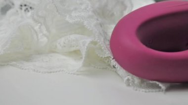 Klitoral vajinal vibratör beyaz bir tabakta dönüyor.