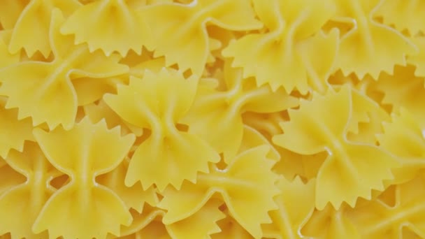 Farfalle, vlinderdas in de vorm van droge pasta in rotatie.Studio schot. close up, achtergrond — Stockvideo