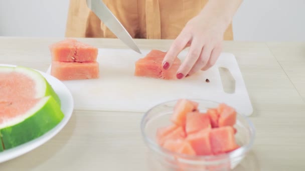 De vrouw deed gesneden rode watermeloen stukken in een glazen schaal — Stockvideo