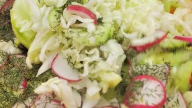 Yakın plan, turp salatası salatalık lahana, üzerine dereotu serpiştirilmiş.