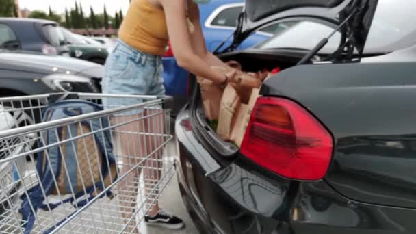 Rzym Włochy. 04 lipca. 2021. Kobieta wkłada zakupy do bagażnika samochodu. zakupy w opakowaniach tekturowych — Wideo stockowe