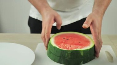 Adam tatlı yemek için karpuz dilimliyor..