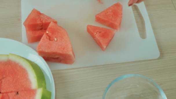 Mujer blanca cortando rebanadas de sandía madura con cuchillo y poniendo en tazón. Chica de corte de sandía roja sin semillas para picnic, comer. Concepto de comida saludable, fruta de temporada, fiesta de verano, aperitivos. — Vídeos de Stock